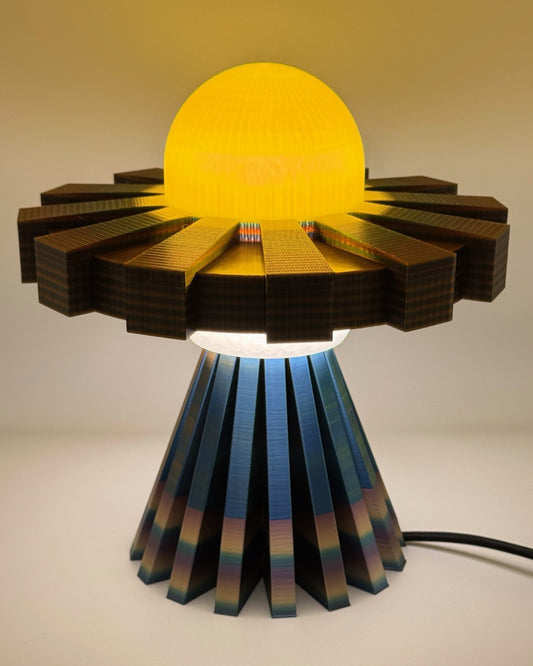 Golden Halo UFO lamp glowing gold over a rainbow metallic base