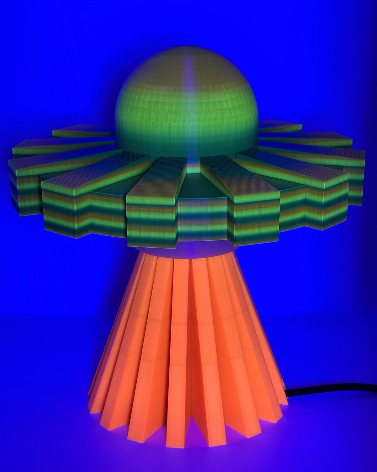 Iridescent UFO lamp glowing under blacklight