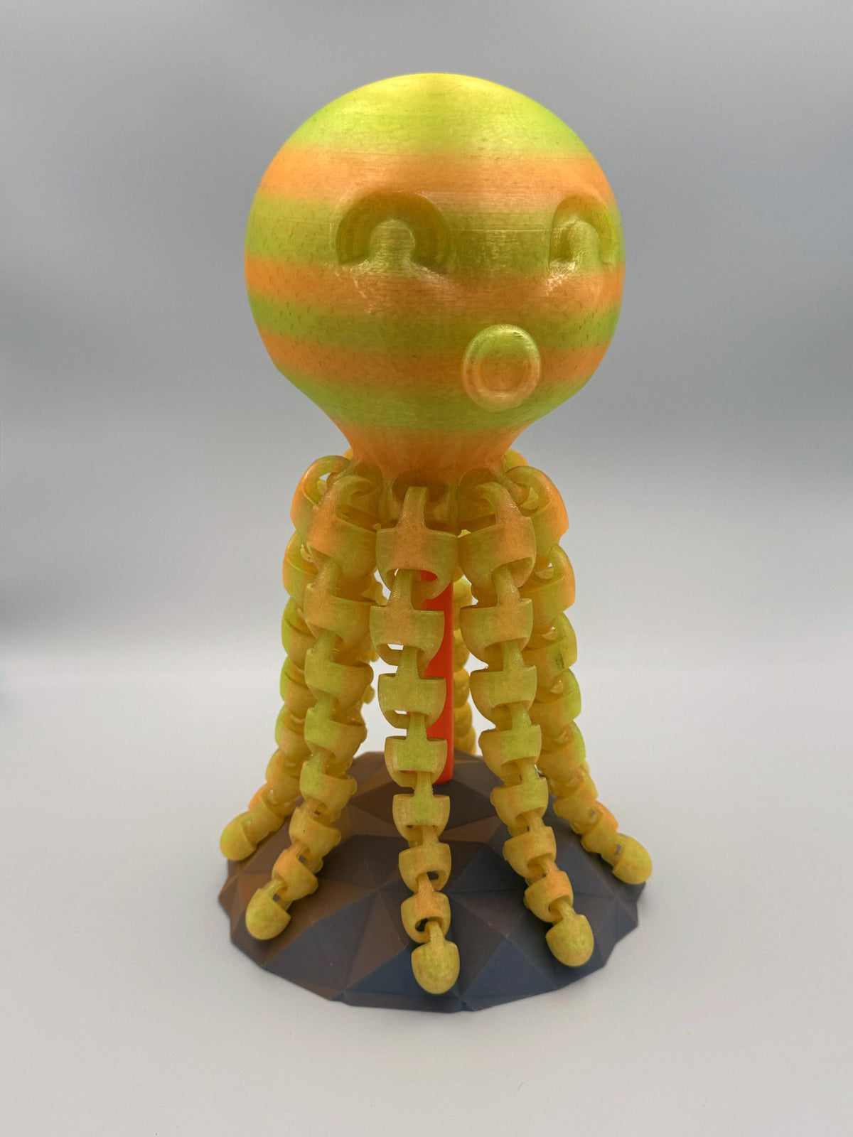 Striped yellow and orange Kraken 3D printed octopus totem on stand