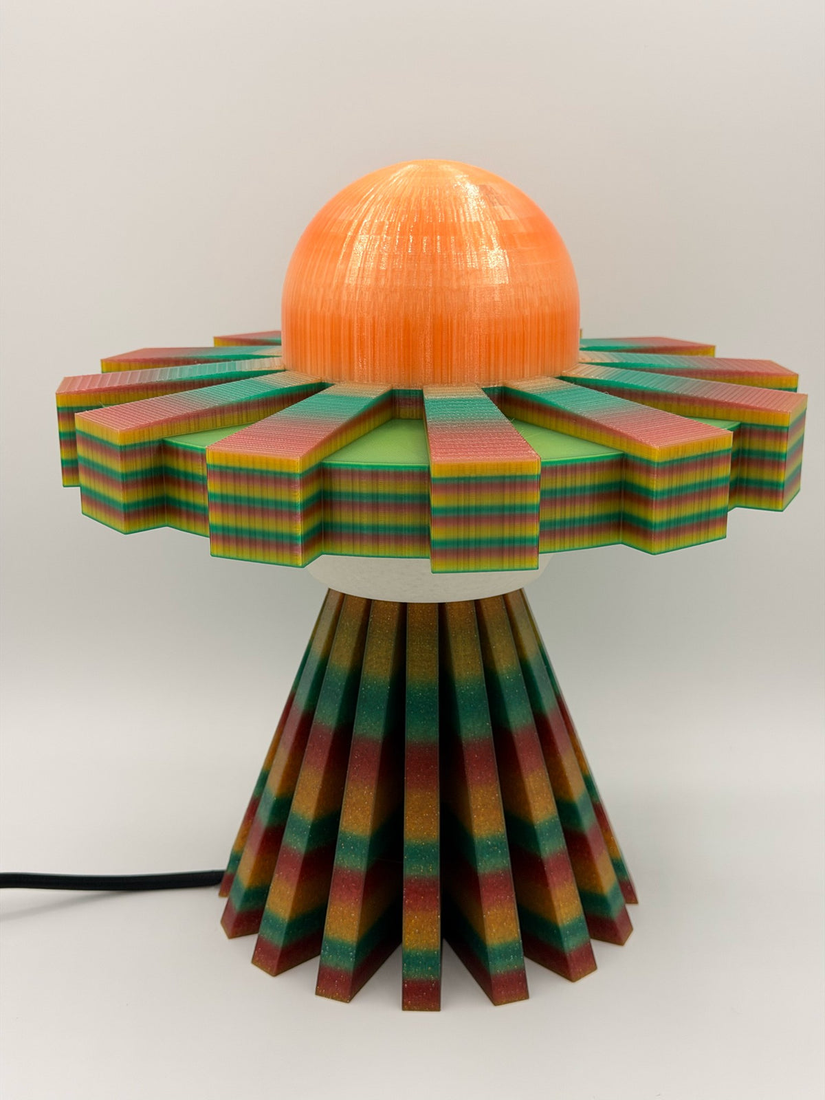 Orange multicolor 3D printed UFO lamp with orange dome, rainbow striped saucer and multicolor striped base