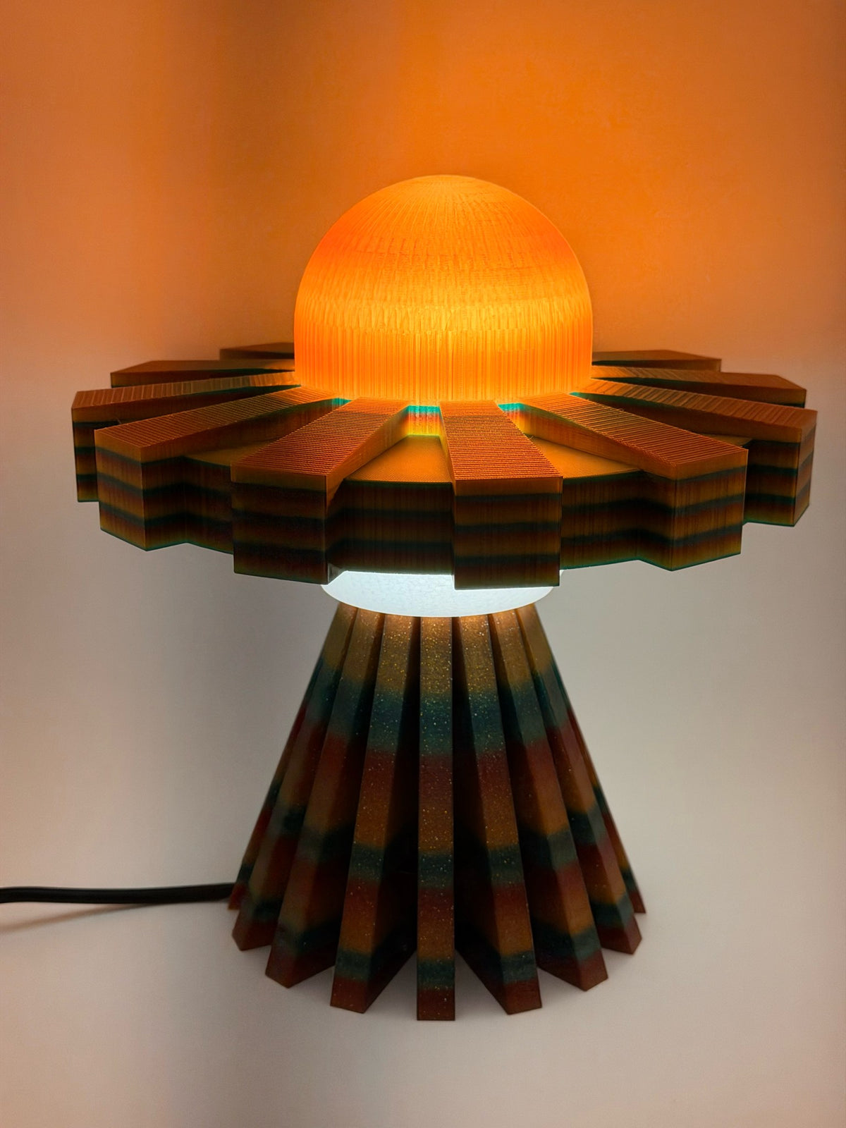 Orange multicolor UFO lamp switched on with a glowing sunset-orange dome