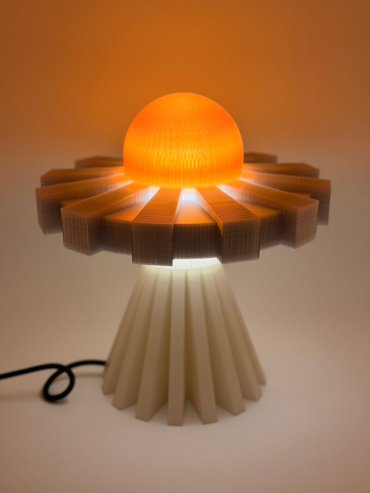 Tangerine and silver UFO lamp glowing in a dim room