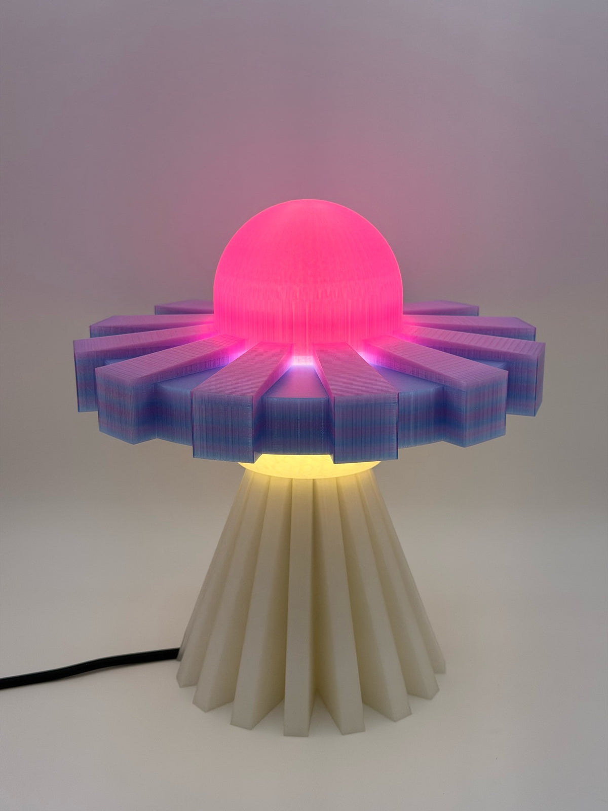 Hot pink and lavender UFO lamp switched on with glowing pink dome