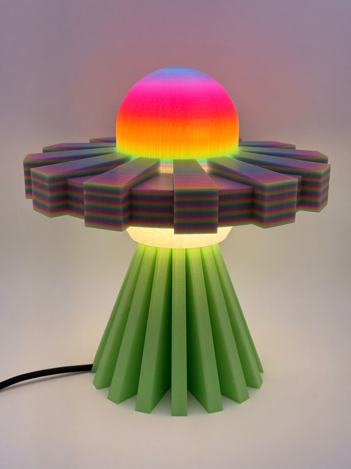 Rainbow and green UFO lamp switched on with glowing rainbow dome