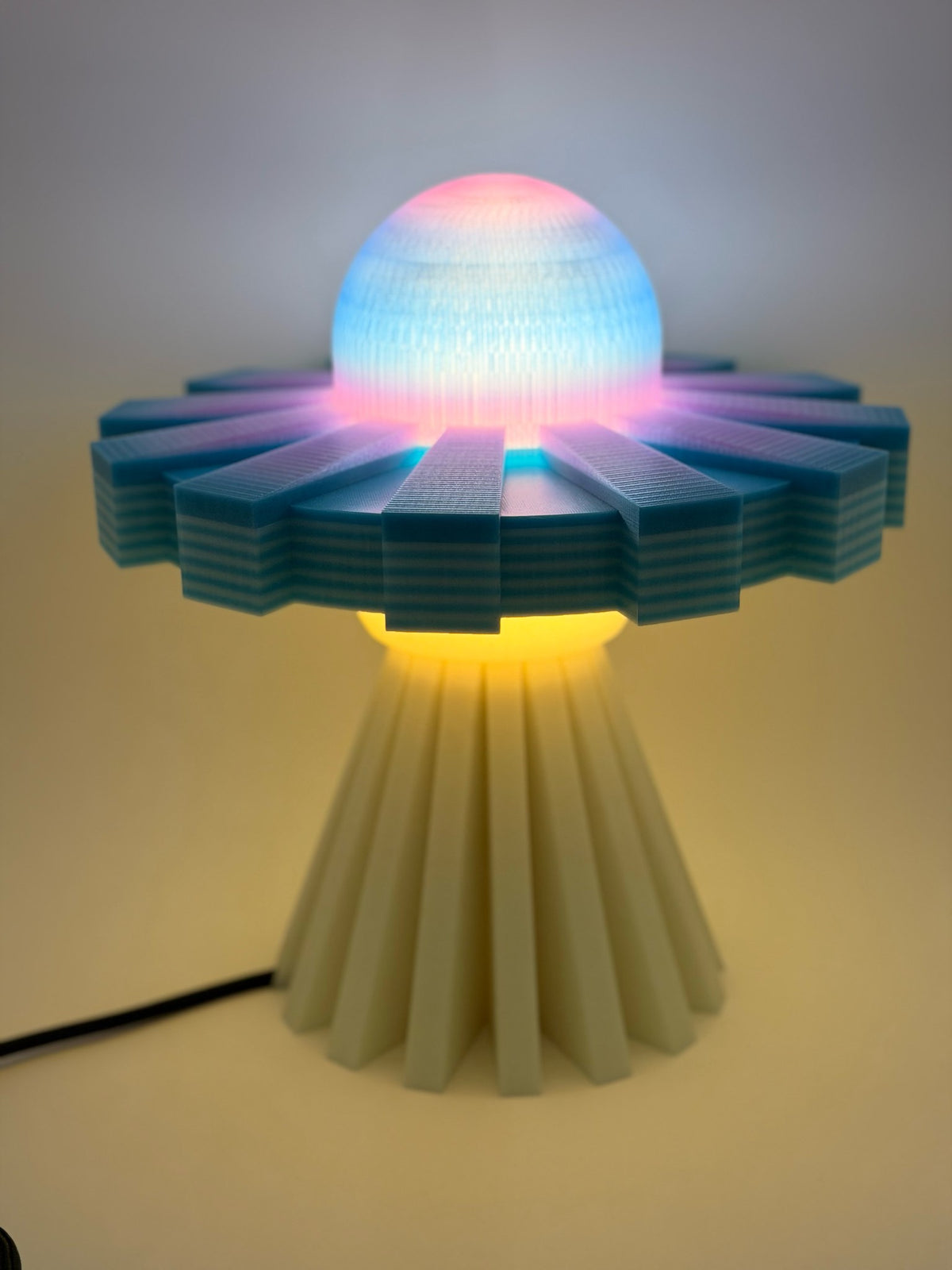 Cotton candy UFO lamp switched on, dome glowing pink and blue