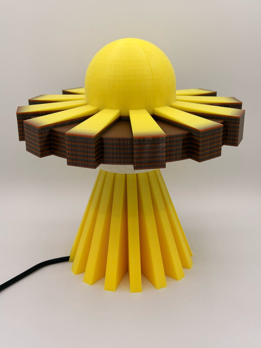 Golden yellow 3D printed UFO lamp with yellow dome, yellow and black saucer and yellow base, lamp off