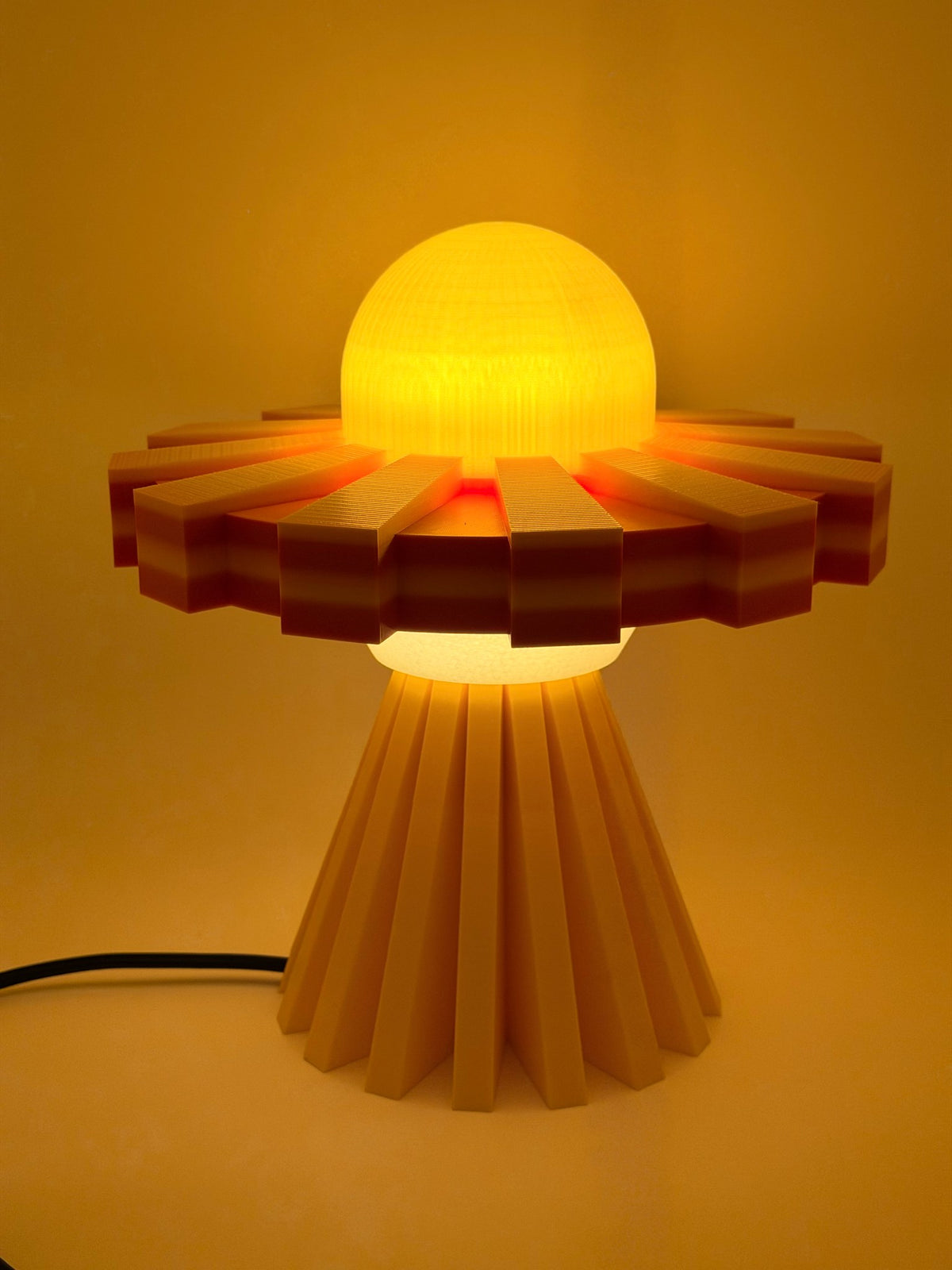 Sunburst yellow and orange UFO lamp switched on with glowing yellow dome