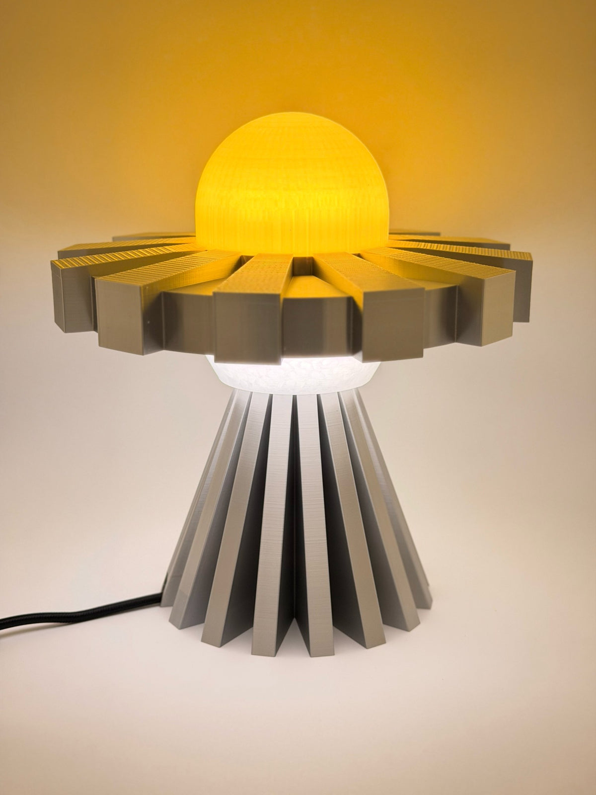 Lemon and silver UFO lamp switched on with glowing yellow dome