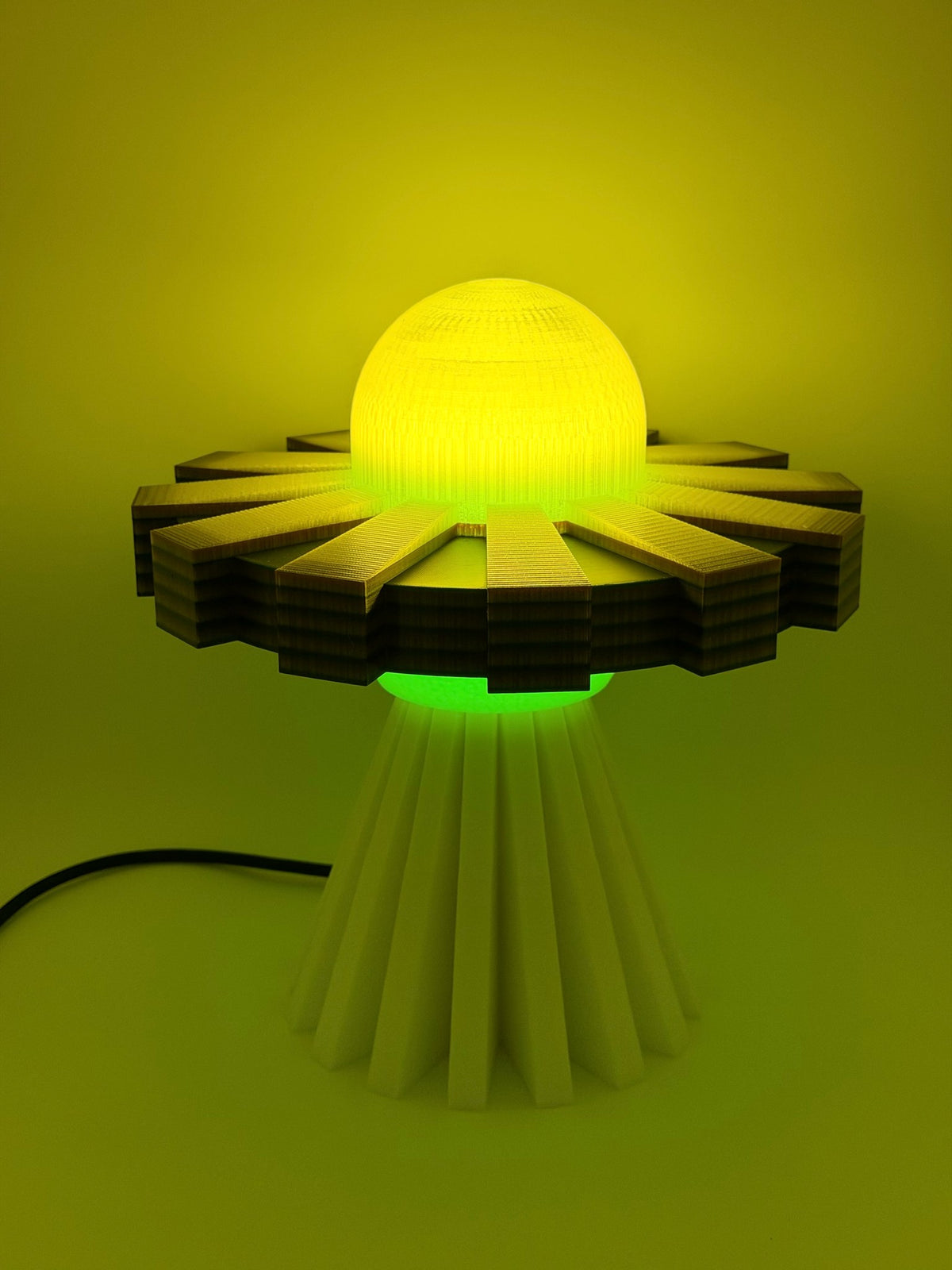 Lemon and cream UFO lamp switched on with glowing yellow dome and green underglow